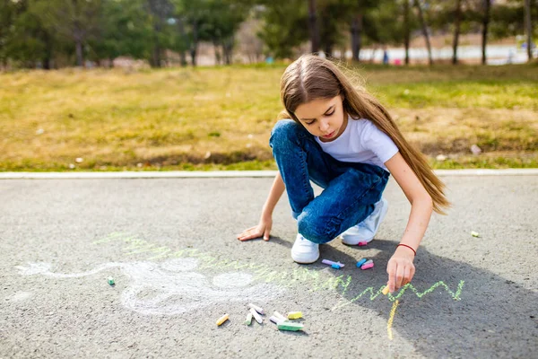 Kleines Mädchen mit kreativem Handwerk Hobby Zeichnung Elektro auf dem Asphalt mit Kreide Auto Umwelt, umweltfreundlich, Energie sparen im Park an Sommertagen — Stockfoto