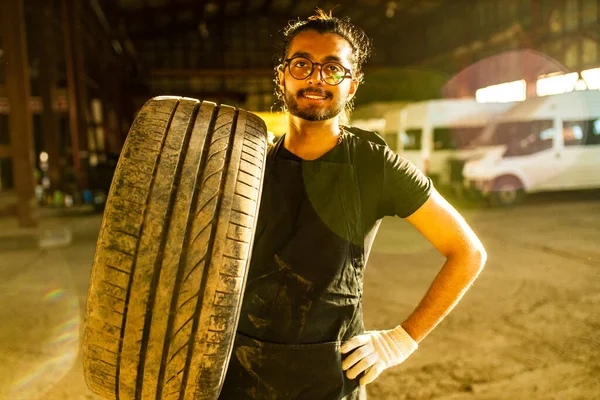 Latino ispanico meccanico auto in uniforme sta esaminando una macchina mentre si lavora in servizio auto — Foto Stock