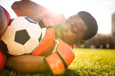 Futbol sahasında arka planda sanal gerçeklik gözlüklü mutlu adam açık havada güneşli yaz gününde bulanık bir konsept.