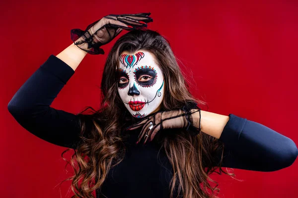 Mujer con el cráneo pintado en su cara para México D a de Muertos Ritual tradicional mexicano en fondo de estudio rojo —  Fotos de Stock