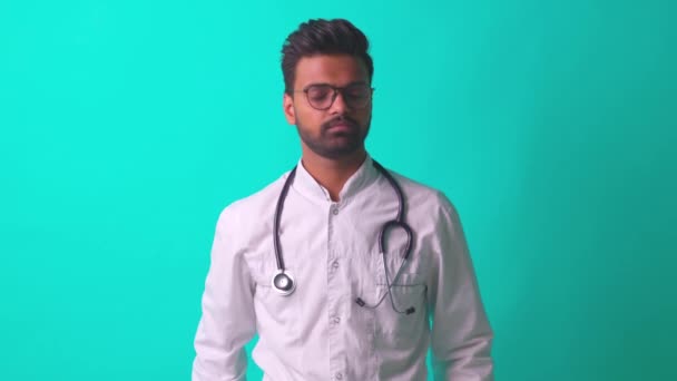 Jonge latino latino latino mediaan man dragen bril met stethoscoop vertellen slecht nieuws in blauwe studio muur achtergrond — Stockvideo