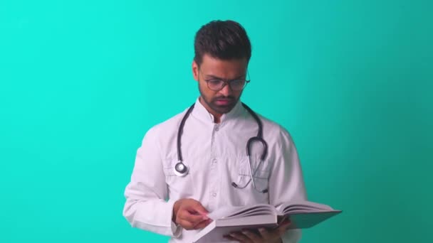 Steteskoplu beyaz önlüklü Pakistanlı doktor mavi stüdyonun arka planında kendini güvende hissediyor. — Stok video