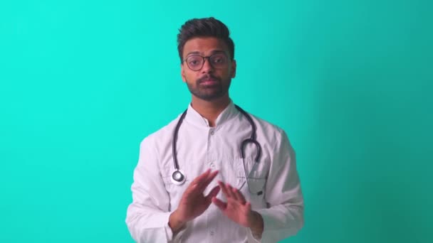 Jonge latino latino latino mediaan man dragen bril met stethoscoop in blauwe studio muur achtergrond — Stockvideo