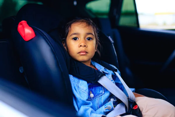 Menina de raça mista no assento do carro com cinto apertado — Fotografia de Stock