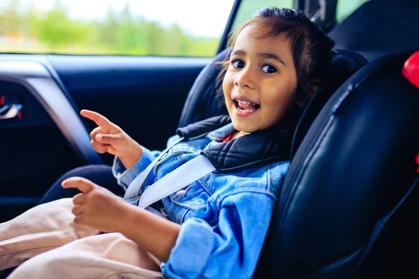 Menina de raça mista no assento do carro com cinto apertado — Fotografia de Stock