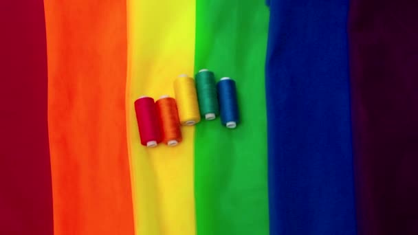 Разноцветные куски ткани и нити на столе подготовки к параду аттракционов lgbt — стоковое видео