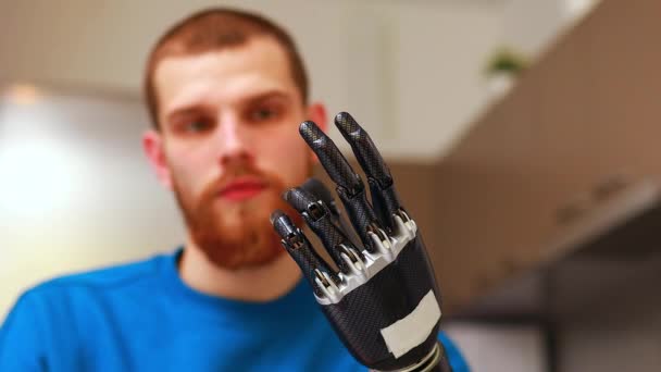 Молодий чоловік з робототехнікою механічна сучасна біонічна рука вдома — стокове відео