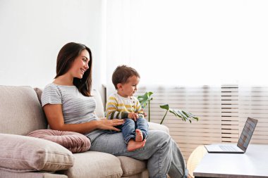 Evde kal anne. Bebeğine bakarken uzaktan bilgisayarla çalış. Annelik iznindeki genç anne, yeni yürümeye başlayan çocuğuyla masa başında serbest çalışmaya çalışıyor. Kapat, kopyala boşluk, arkaplan