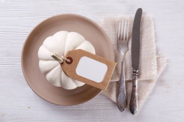Şükran Günü masa hazırlama konsepti. Geleneksel bayram sembolü olarak seramik tabak, çatal, bıçak ve mini balkabağı. Üst görünüm, kapat, boşluğu kopyala, arkaplan.