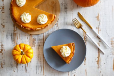 Ahşap masada geleneksel Şükran Günü yemeği. Portakal aromalı ev yapımı balkabağı turtası, kabuklu ve dekoratif ürünler. Şükran Günü masa ayarlama kavramı. Üst görünüm, kapatma, kopyalama alanı, arkaplan.