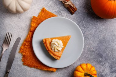 Ahşap masada geleneksel Şükran Günü yemeği. Portakal aromalı ev yapımı balkabağı turtası, kabuklu ve dekoratif ürünler. Şükran Günü masa ayarlama kavramı. Üst görünüm, kapatma, kopyalama alanı, arkaplan.