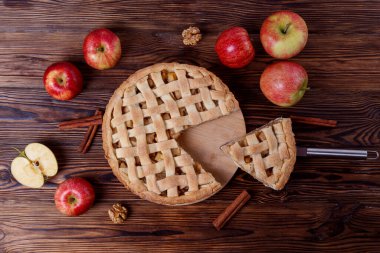 Geleneksel Amerikan Teşekkürleri. Organik elmalı turta, ahşap masada tarçın çubukları. Altın hamura pişirilmiş ev yapımı meyveli tart. Kapat, boşluğu kopyala, üst görünüm, arkaplan.