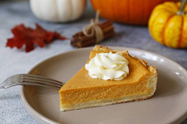 Ahşap masada geleneksel Şükran Günü yemeği. Portakal aromalı ev yapımı balkabağı turtası, kabuklu ve dekoratif ürünler. Şükran Günü masa ayarlama kavramı. Üst görünüm, kapatma, kopyalama alanı, arkaplan.