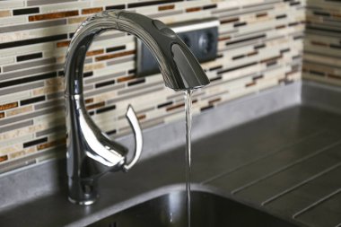 Mutfakta cilalanmış krom musluk ve paslanmaz çelik leğen yakın çekim. Boşluğu kopyala, arkaplan.