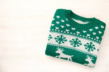 Çirkin Noel süveteri konsepti. Geyik ve kar taneleri desenli beyaz renkli şenlikli atlayıcı. Kapat, üst görünüm, düz görünüm, kopyalama alanı, arkaplan.