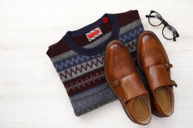 Üst katlı süveter, şenlikli ve kahverengi erkek ayakkabısı. Erkek kıyafetleri. Kapat, boşluğu kopyala, düzleştir, arkaplan.