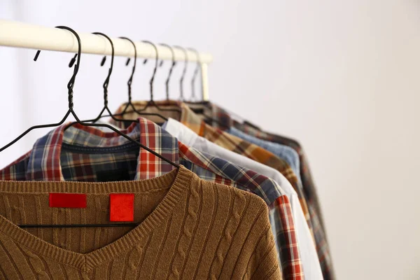 Men\'s hip clothing store sale concept. Row of different stylish male clothes hanging on rack in hipster fashion show room in shopping mall. Copy space for text, background.