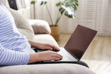 Ev kavramından çalış. Dizüstü bilgisayarda yazı yazan bir kadının el görüntüsü. Oturma odasında çalışan serbest çalışan bir kadın. Kapat, metin için boşluk kopyala.