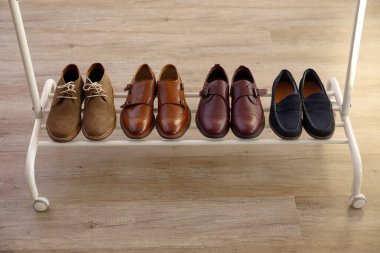 Arka arkaya bir sürü farklı tarz erkek ayakkabısı. Yakın çekim chukka çizmeleri, tek ve çift katlı keşiş kayışlı okfordlar, kahverengi, siyah ve bordo broglar. Üst görünüm, kopyalama alanı, düz görünüm, tahta arkaplan