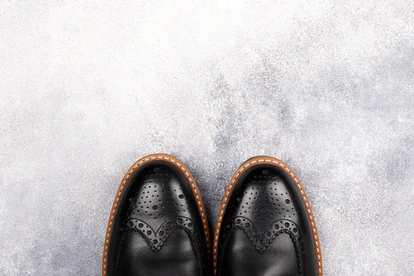 A pair of black patent leather oxford shoes isolated on white background. Versatile business casual dress wingtip. Top view, copy space for text, flat lay.