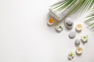 Spa salonu için sembolik nesnelerle kompozisyon. Kozmetik işlemler için taş terapisi özellikleri. Kavramsal görüntü, kayalar ve çiçekler dengeyi temsil ediyor. Kapat, boşluğu kopyala, üst görünüm, arkaplan.