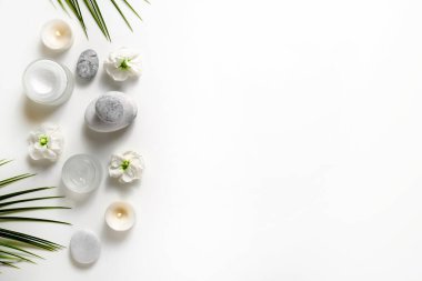 Spa salonu için sembolik nesnelerle kompozisyon. Kozmetik işlemler için taş terapisi özellikleri. Kavramsal görüntü, kayalar ve çiçekler dengeyi temsil ediyor. Kapat, boşluğu kopyala, üst görünüm, arkaplan.