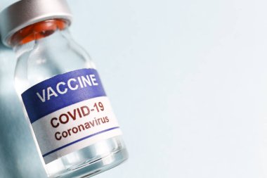 Kovid 19 virüsüne karşı aşı için makro doz antiviral aşı şişesi. Metin için kopyalama alanı olan mavi arkaplanda izole edilmiş. Kapat, üst görünüm.