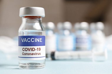 Kovid-19 virüsüne karşı aşı için şırıngalı antiviral aşı şişesi. Metin için kopyalama alanı olan bulanık arkaplan. Kapat, üst görünüm.