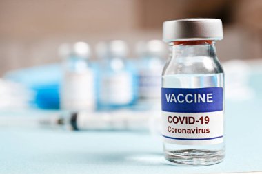 Kovid-19 virüsüne karşı aşı için şırıngalı antiviral aşı şişesi. Metin için kopyalama alanı olan bulanık arkaplan. Kapat, üst görünüm.