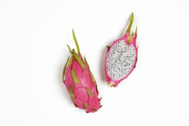 Pitaya - an exotic low-calorie nutrient-dense fruit with high amount of fiber and magnesium. Whole and halved dragon fruit with visible pulp texture, isolated on white. Close up, copy space, top view. clipart