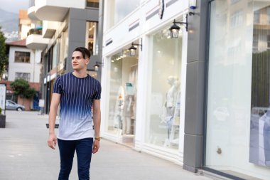 Şehir sokaklarında Arap kökenli genç yakışıklı bir adamın portresi. Hippi saç stili, günlük kıyafetler giyen İranlı bir adam. Kapat, metin için boşluk kopyala.