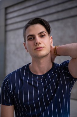 Şehir sokaklarında Arap kökenli genç yakışıklı bir adamın portresi. Hippi saç stili, günlük kıyafetler giyen İranlı bir adam. Kapat, metin için boşluk kopyala.