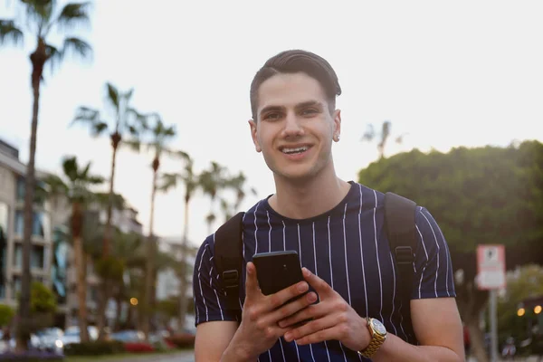 Portrait of young handsome man of Arabic ethnicity on the city streets. Iranian guy over with hipster hairstyle wearing casual attire. Close up, copy space for text.