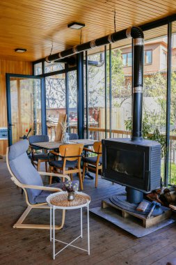 Şöminenin yanındaki boş koltuk camdan duvarları olan bir odanın içinde. Kapat, metin ve arkaplan için boşluk kopyala.