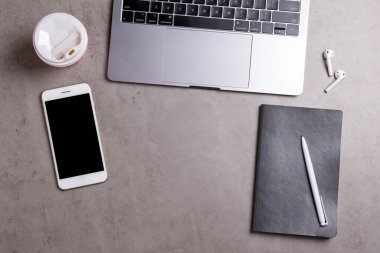 Minimalist çalışma alanının kırpılmış görüntüsü. Metalik gri dizüstü bilgisayarlı beton desenli bir masa. Müteahhit konseptinin işyeri. Arkaplan, metin için boşluk kopyala, düz yat, kapat, üst görünüm.