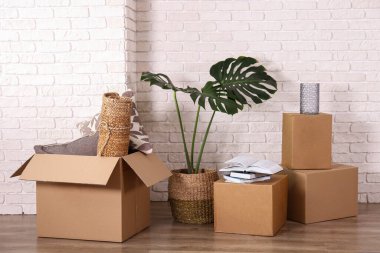 Yeni boş dairede imzalanmamış bir sürü kutu. Geniş mobilyalı, paketsiz karton kutu yığını olan bir oda. İç arkaplan, metin için kopyalama alanı.