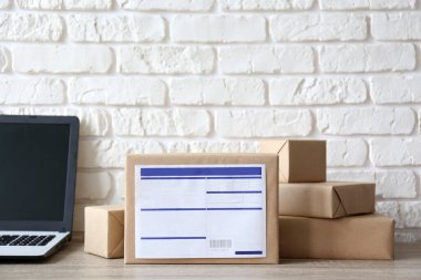 Kargo etiketli el sanatları kağıdına sarılı farklı boyutlarda paketler. Laptop ve paketler masada. Ekommerce yerine getirme konsepti için nakliye yazılımı. Kapat, kopyala boşluk, arkaplan.