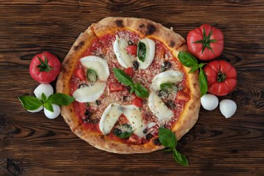 Bufalo mozzarella ile fırında pizza, parmesanlı reggiano peyniri, fesleğen ve ançüez. Beyaz ahşap masa arkaplanlı geleneksel İtalyan yemeği. Kapat, boşluğu kopyala, üst görünüm.