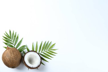 Hindistan cevizlerinin üst görüntüsü, kağıt üzerinde yarıya bölünmüş ve yarıya bölünmüş arka planda metin için bir sürü fotokopi alanı var. Tropik palmiye ağacının çiğ meyveli arka planı. Düz yatıyordu.