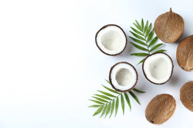 Hindistan cevizlerinin üst görüntüsü, kağıt üzerinde yarıya bölünmüş ve yarıya bölünmüş arka planda metin için bir sürü fotokopi alanı var. Tropik palmiye ağacının çiğ meyveli arka planı. Düz yatıyordu.