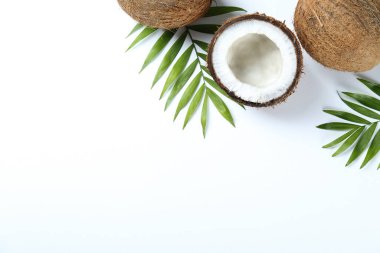 Hindistan cevizlerinin üst görüntüsü, kağıt üzerinde yarıya bölünmüş ve yarıya bölünmüş arka planda metin için bir sürü fotokopi alanı var. Tropik palmiye ağacının çiğ meyveli arka planı. Düz yatıyordu.