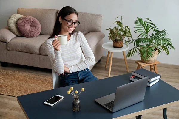 Çevrimiçi eğitim kavramı. Gözlüklü güzel esmer kadın bir grup video görüşmesine katılıyor. Evde okuyan bayan üniversite öğrencisinin portresi. Kapat, kopyala boşluk, arkaplan.