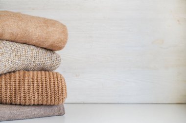 Bir sürü örülmüş pastel renkli süveter farklı örgü desenleri yığılmış, açıkça görülebilen doku. Şık sonbahar kış mevsimi örgü giysileri. Kapat, metin için boşluk kopyala.