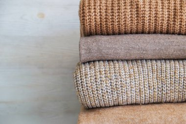 Bir sürü örülmüş pastel renkli süveter farklı örgü desenleri yığılmış, açıkça görülebilen doku. Şık sonbahar kış mevsimi örgü giysileri. Kapat, metin için boşluk kopyala.