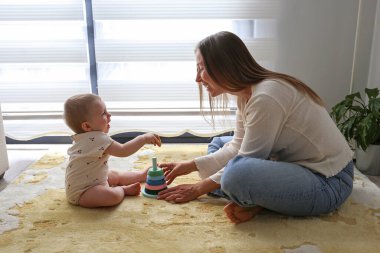 Anne ve bebek piramit oyuncaklarını üst üste istifleyerek oynuyorlar. Boşluğu kopyala, arkaplan.