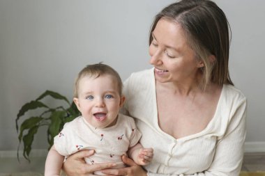 Mom and a baby playing and laughing together. Copy space, background.