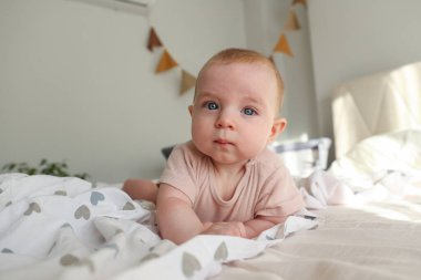 Yatakta oynaşan bir bebek. Boşluğu, arkaplanı kopyala. Boşluğu, arkaplanı kopyala.