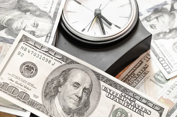 Stack of one hundred dollar bills with clock — Stock Photo, Image