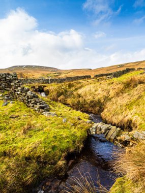 Dağdan çok uzakta, yağmur bulutları, deresi ve eski bir yolu olan açık bir bozkır. Ölü Mans Tepesi. Nidderdale 'de. Yorkshire Dales