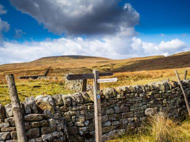 Arka planda dağlar olan bir su deposunun kenarındaki tahta levhalar. Yara Evi. Nidderdale 'de. Yorkshire Dales Ulusal Parkı
